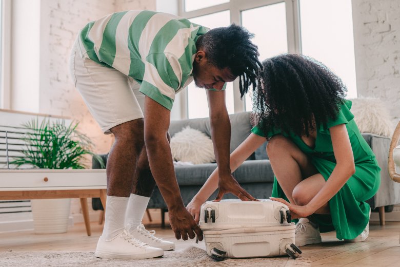 un garçon et une jeune fille ouvrant une valise dans un appartement